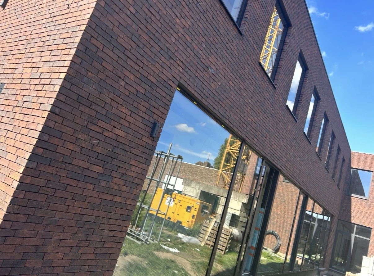 Bakstenen gebouw met een brede beglaasde benedenverdieping