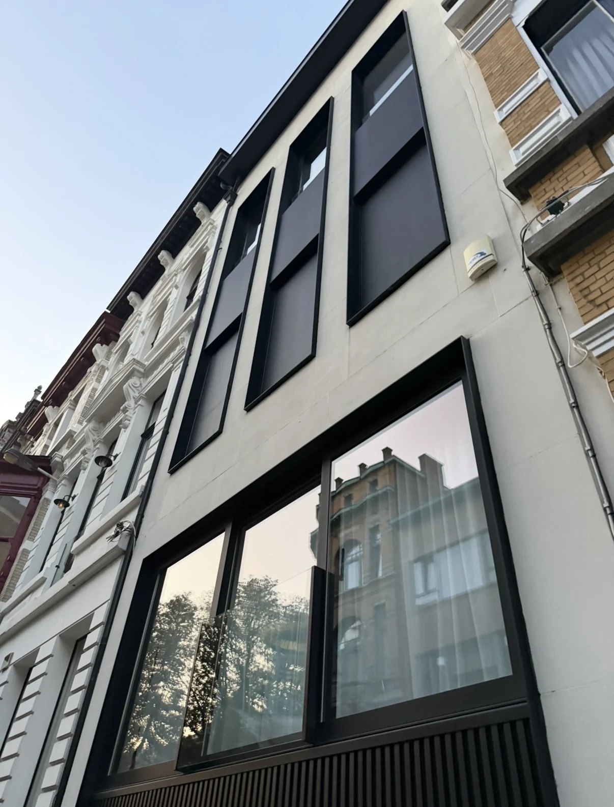 Stadsgevel met donker schrijnwerk en grote ramen