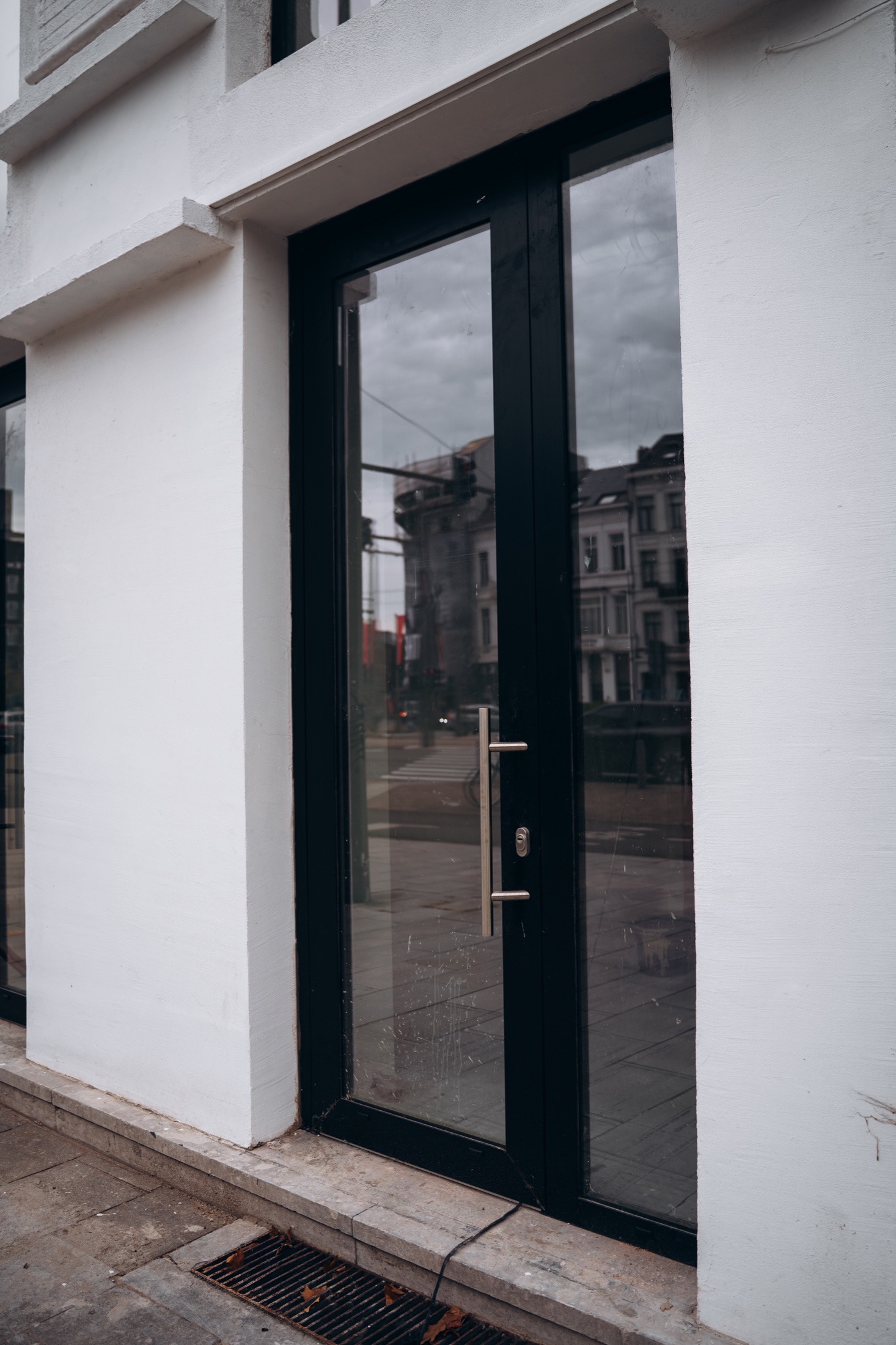 Zwarte glazen inkomdeur in een witte stadsgevel