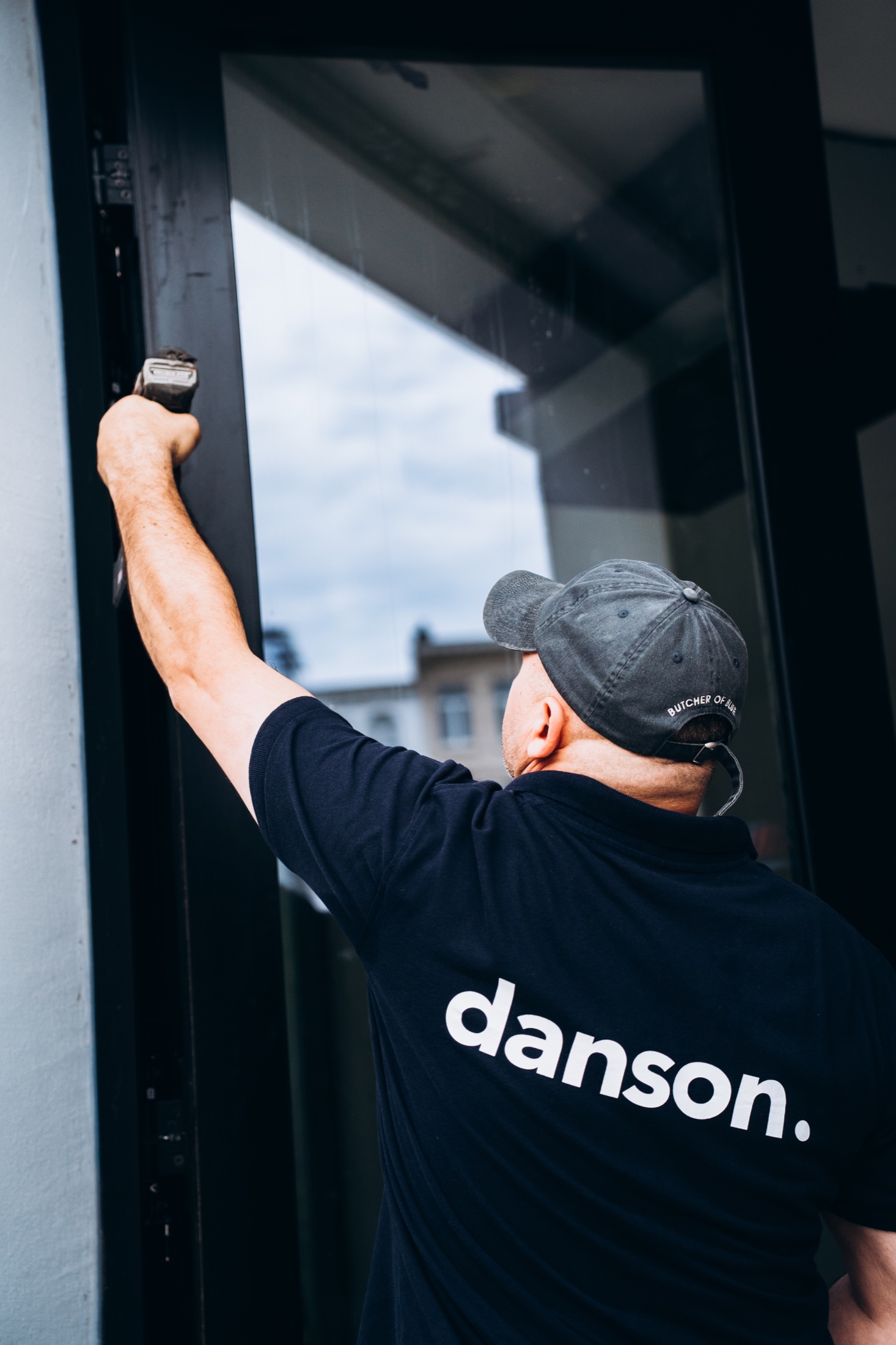 Danson-vakman die een donker raam zorgvuldig afregelt